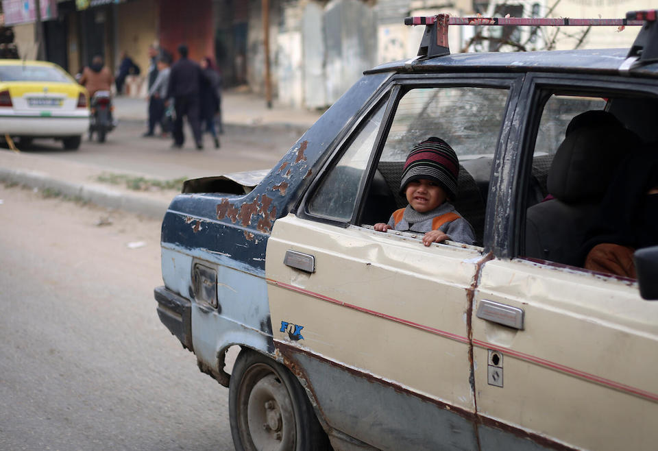 On Jan. 11, 2024, a smzll child looks out of the window of an old car on a street in the Gaza Strip.