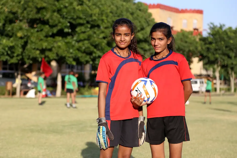 In Ajmer district, Rajasthan, India, Gayatri,18, and her sister Savitri , 15, pause during a practice session for a UNICEF-supported girls’ soccer initiative to tackle gender inequality.