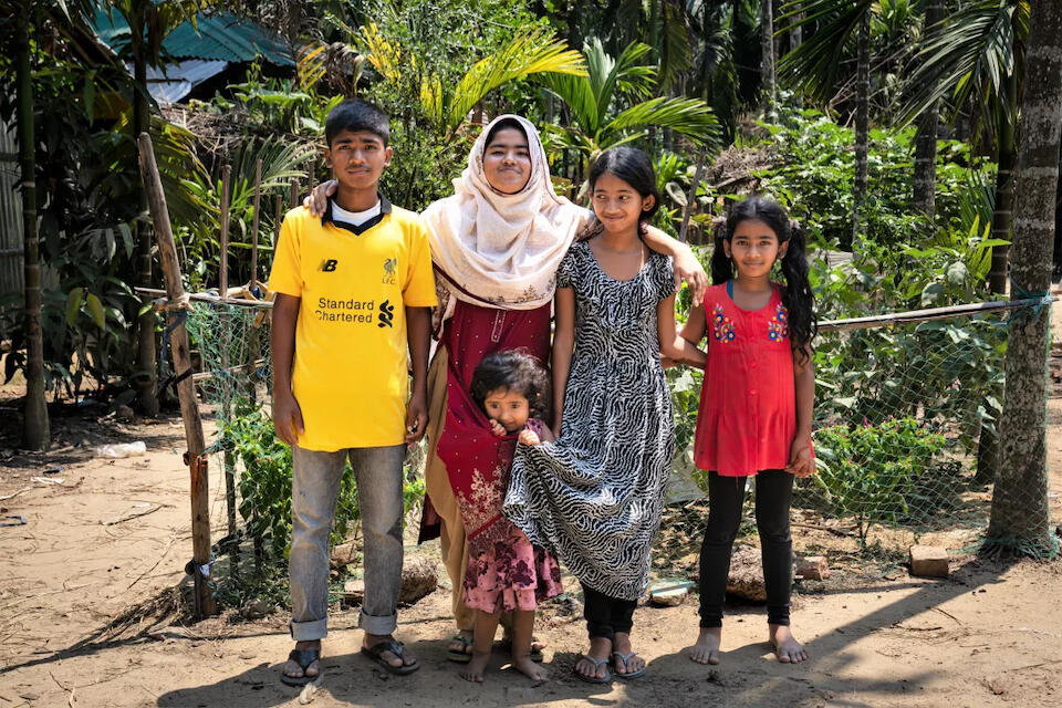 Sixteen-year-old Tahmina, center left, stands with her siblings outside the family home. Unable to pay her school fees, Tahmina’s parents almost married her off earlier this year, then volunteers from a UNICEF-supported protection hub intervened. 