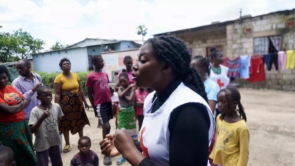In Lusaka, Zambia, 26-year-old nurse Susan Peleti, a UNICEF-supported volunteer, speaks to community members about cholera prevention as part of a UNICEF-supported campaign.