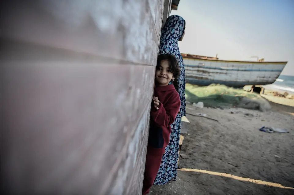 Forced to evacuate their home in Gaza City, Hanadi, top, her husband and their six children are living in a fisherman's hut on the coast of the City of Rafah in the southern Gaza Strip.