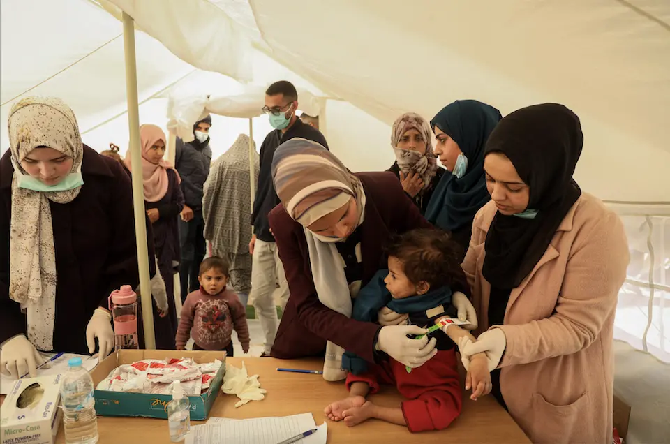 Children are getting their middle-upper-arm-circumference (MUAC) measured as part of their malnutrition screening at a UNICEF-supported pediatrician clinic tent in Rafah city, south of the Gaza Strip.