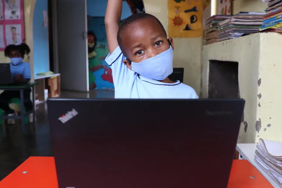 A student raises his hand in a classroom lesson in Zimbabwe during the height of the COVID-19 pandemic.