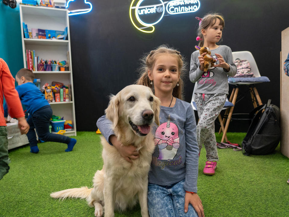 Adelina, 7, plays with a dog named Julie during a canine-assisted therapy class at a UNICEF Spilno Child Spot in Kharkiv, Ukraine, one of over 200 centers where children and caregivers impacted by the war in Ukraine can get services and support, including mental health and psychosocial support..