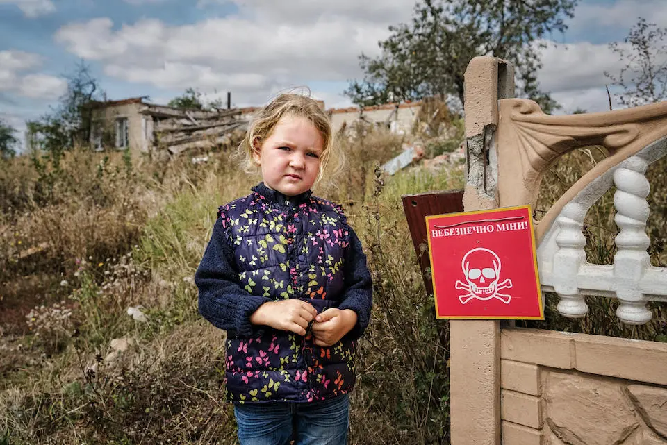 In Chistovodivka, a village in the Kharkiv region of Ukraine, 4-year-old Veronika stands near a sign that reads "Danger of Mines."