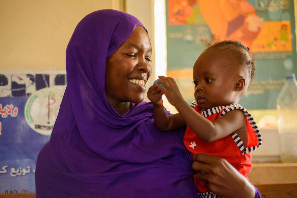 A mother holds her 1-year-old daughter who is receiving therapeutic food at a UNICEF-supported treatment and care center in Port Sudan, Sudan.