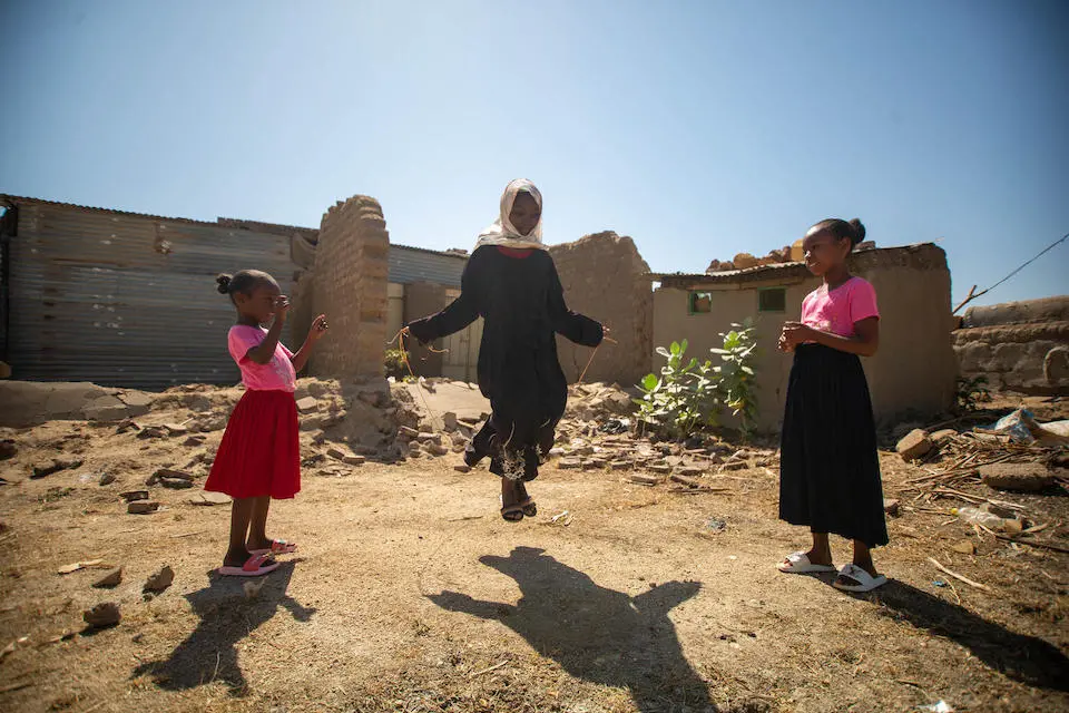 Child rights advocate Fiyha jumps rope with her younger siblings at home in Al- Gabaleen, White Nile State, Sudan.