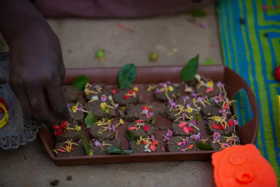 During play activities at a UNICEF-supported safe learning space in Al Salam IDP gathering point, Sudan, in January 2024, children use mold clay to prepare meals similar to what they prepared during the Ramadan season in the past.