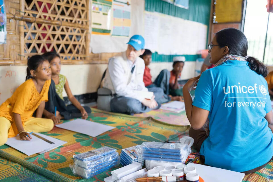 A UNICEF child protection officer interacts with children and colleagues at a UNICEF-supported service center where Rohingya refugee children and adolescents receive a range of services.