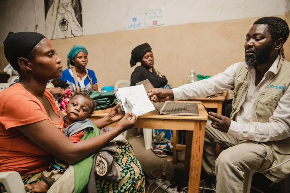 In Minova, South Kivu province, DR Congo, Fatuma Kasesengo, a widow and mother of two, receives a mobile phone from a UNICEF staff member as part of an emergency humanitarian cash transfer distribution program.