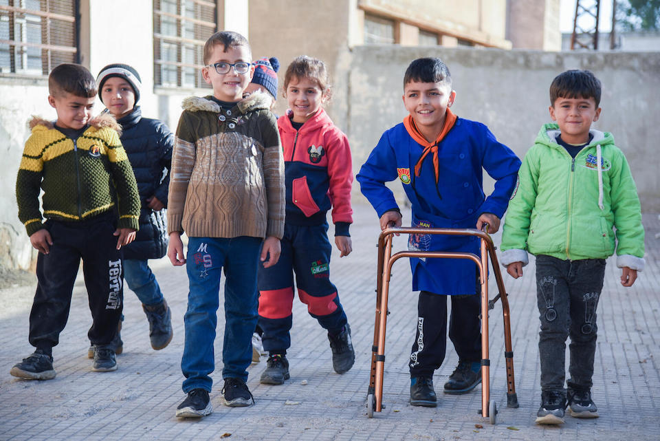Fayez, 10, who has cerebral palsy, engages with several of his classmates at the school where he recently returned with UNICEF's support, in Hama governorate, west central Syria.
