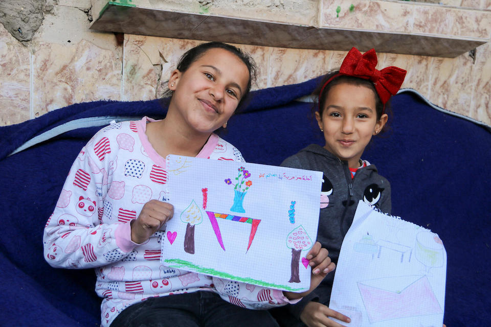 Manar, 13, with her cousin Maria, 8, drawing at home in Deir-ez-Zor, a city in northeast Syria, Feb. 7, 2024.