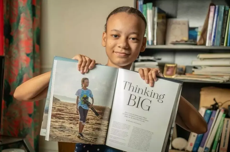 In 2023, Maria holds a copy of Mission magazine, which featured her climate activism work in a special UN edition.