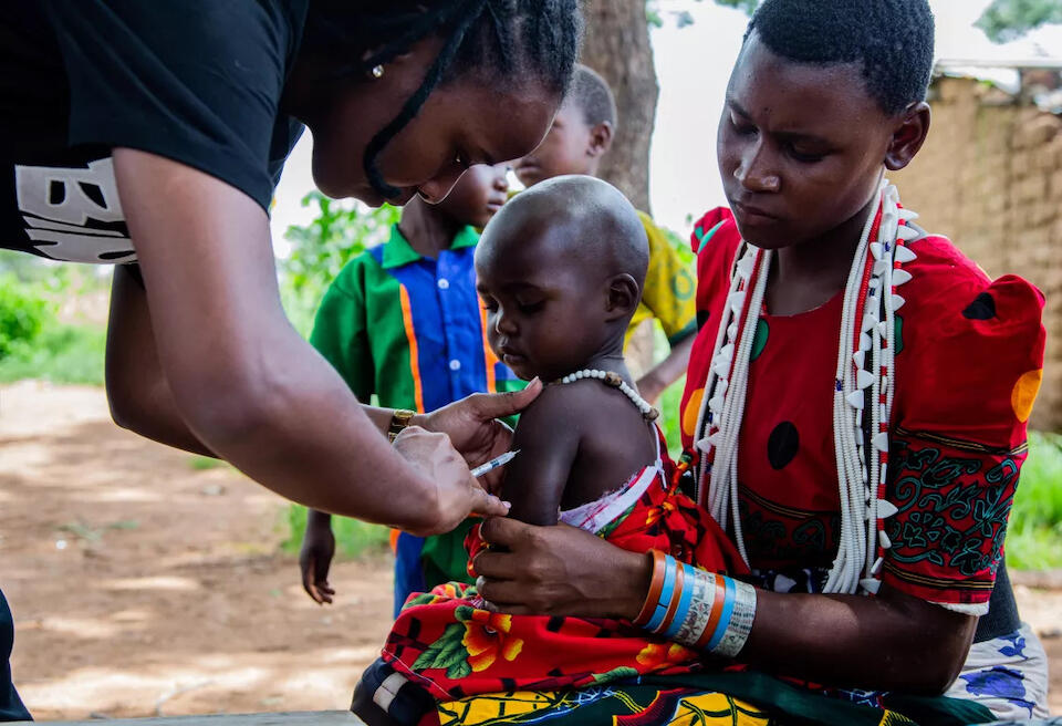 UNICEF-supported health worker Prisca Mkungwa administers the measles-rubella vaccine to a child as part of an integrated services community outreach program in Masiano, a sub-village in Chunya district, Mbeya region, Tanzania.