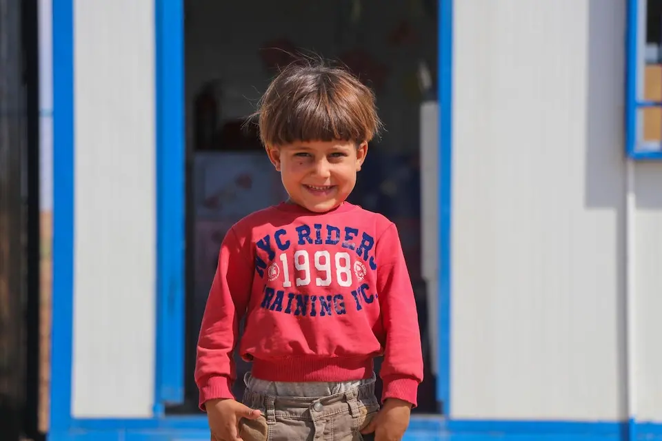 Muhannad stands outside the UNICEF-supported early childhood education center called ‘Dream’ at Ain Khadra IDP camp in Al-Malikiyeh, Al-Hasakeh, Syria, on Sept. 21, 2023.