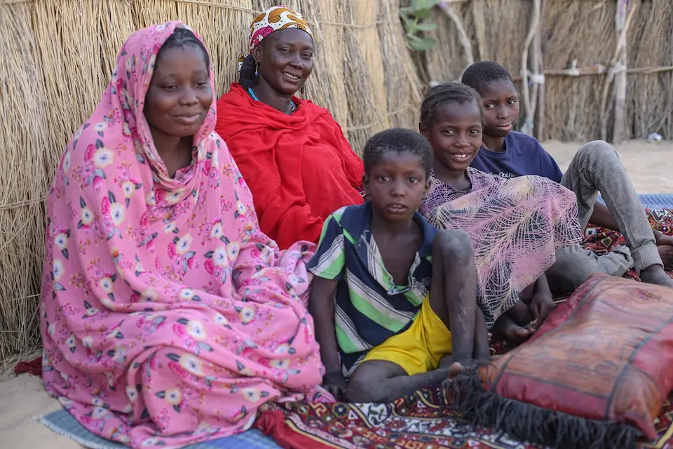 Aissata and her children sit outside their house in the family yard in Mali.