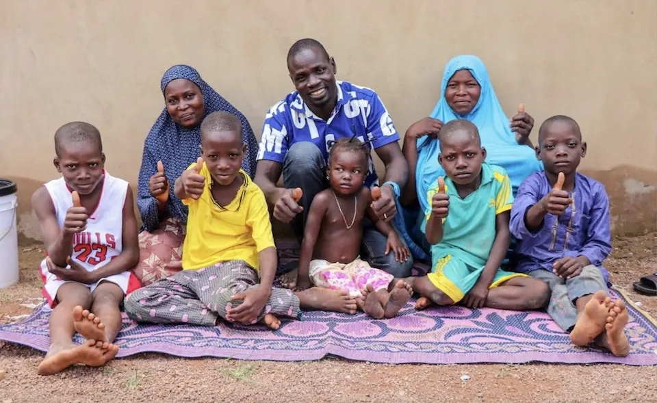 Murtala and his family, refugees living in northern Benin, sit on a mat provided by UNICEF, one of many items included in emergency dignity kits that were distributed to bring relief to displaced populations.