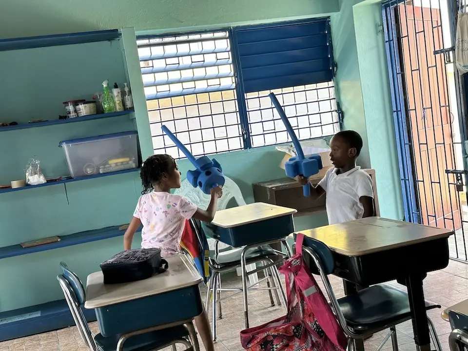 Children play with swords they made from blocks and creative building materials in Kingston, Jamaica.