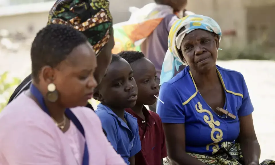 A UNICEF-supported Community Welfare Assistance Committee volunteer, far right, meets with a family affected by cholera in Lusaka district, Zambia.