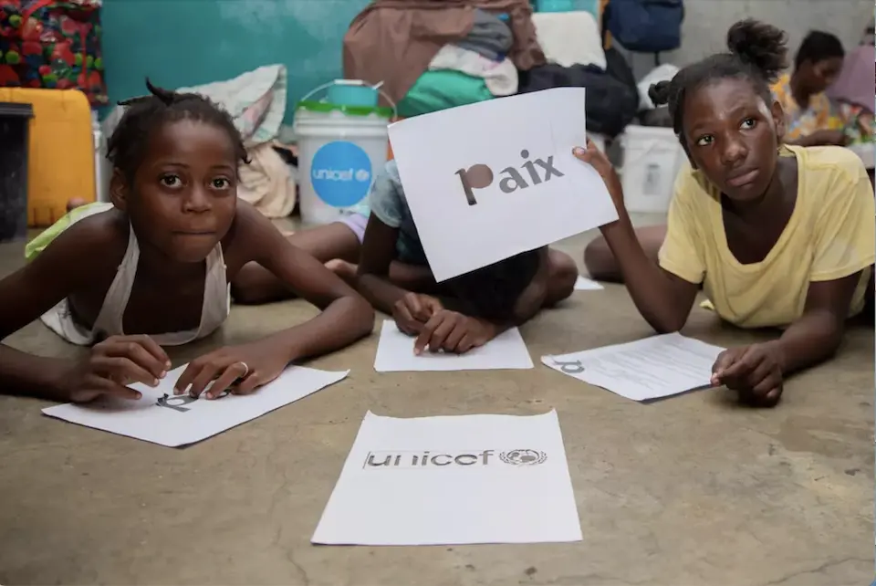 Children display artwork they created during psychosocial and educational activities organized by APADEH, in collaboration with UNICEF, at a school in Port-au-Prince, Haiti.