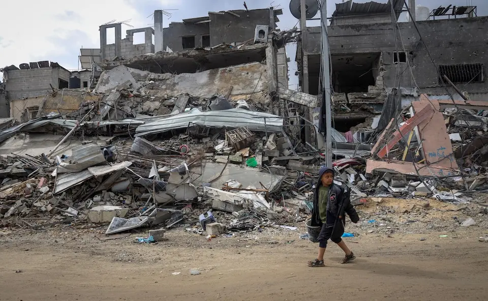 Nine-year-old Tamer walks through the rubble of his destroyed neighborhood in Khan Younis, southern Gaza Strip.