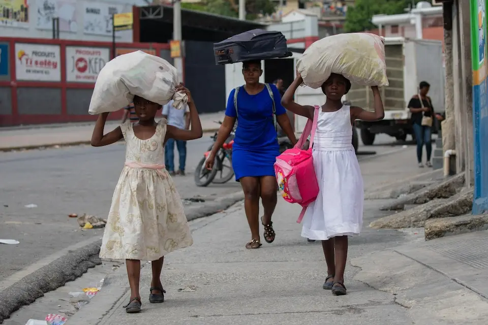 A family flees their home on May 1, 2024, following gang attacks in Solino, at the heart of Port-au-Prince, Haiti's capital.