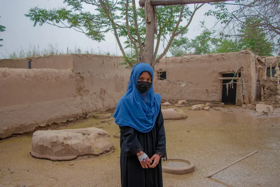 On May 16, 2024, 18-year-old Mahtab stands outside her flooded home in Baghlan province, Afghanistan.