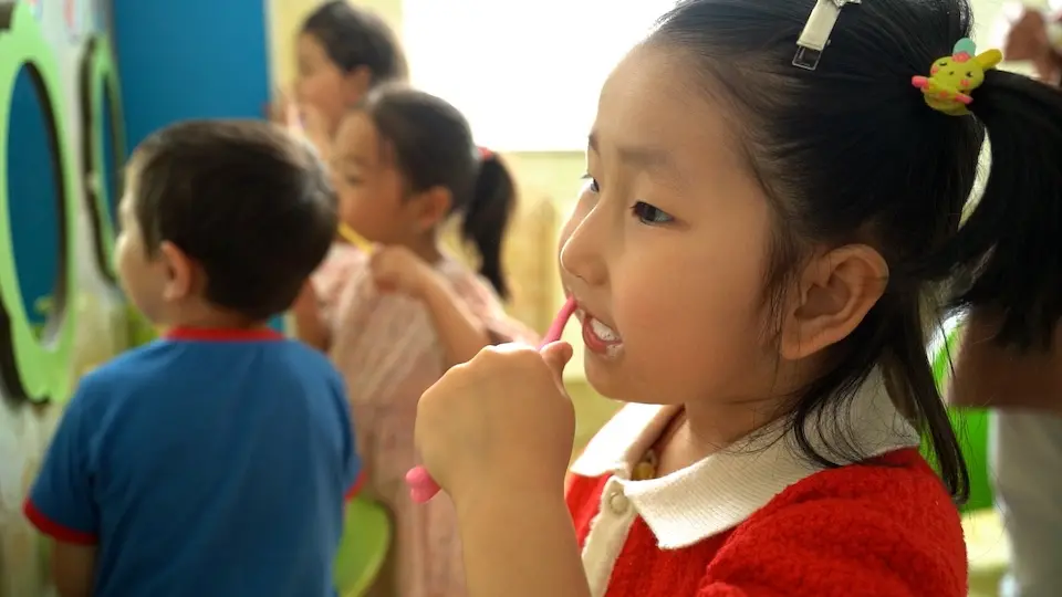 Primary school children in Ulaanbaatar, Mongolia, stand side by side at a row of sinks to brush their teeth, part of a UNICEF-supported program promoting oral health and hygiene.