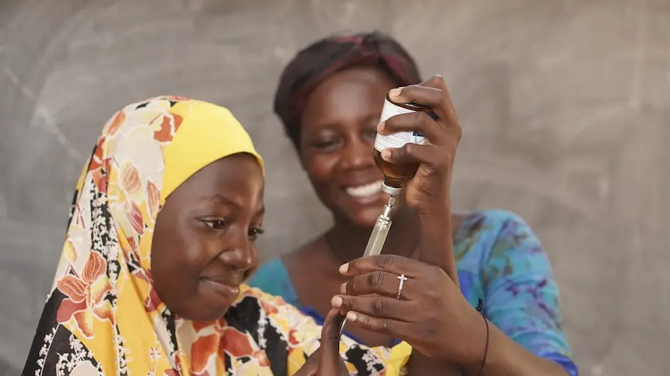 In Burkina Faso, an instructor shows a student how to vaccinate a chicken as part of a modular skills training program supported by UNICEF and Education Cannot Wait.