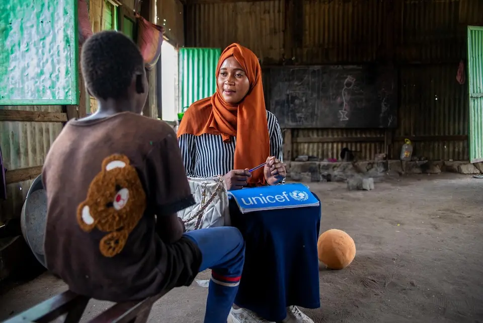 An unaccompanied child meets with a social worker at his home in a camp for internally displaced people's camp in Gedaref state, Sudan. 