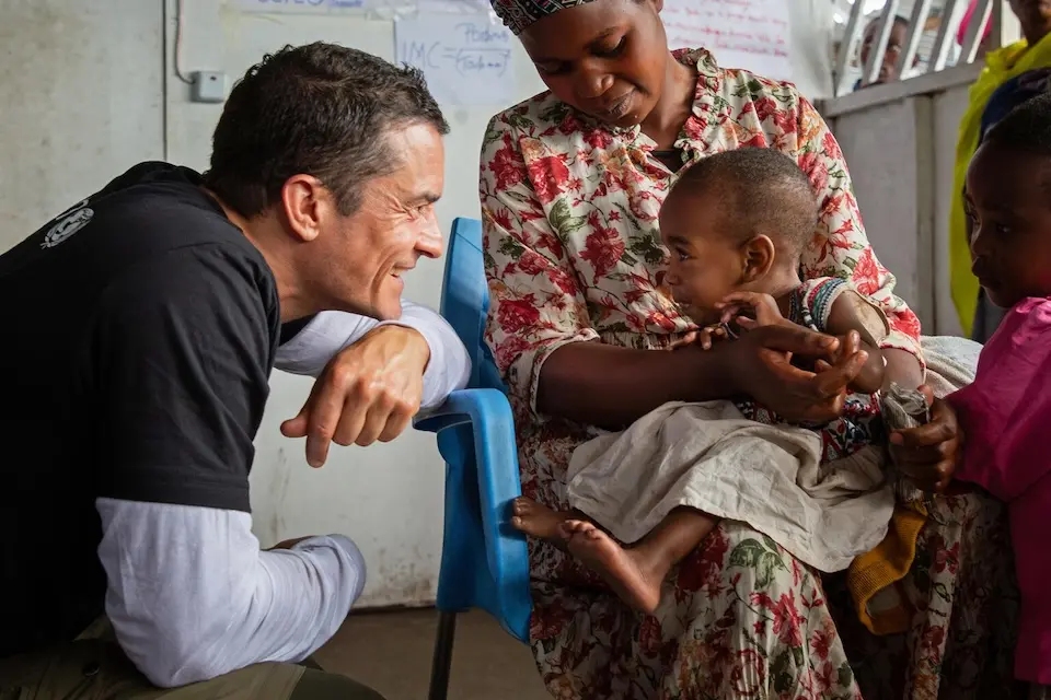 On June 1, 2024, UNICEF Goodwill Ambassador Orlando Bloom greets a child during a visit to the Bushagara site for internally displaced people on the outskirts of Goma in eastern Democratic Republic of the Congo.