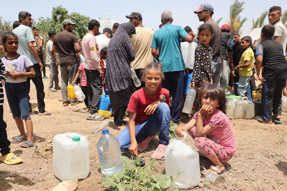 Joudy, 10, with her friend Toleen, 7, fetch water for their families from the UNICEF-supported water tank in Deir al-Balah, central Gaza Strip