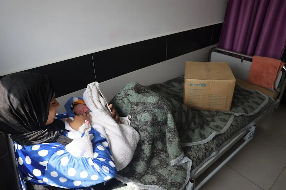 In the Gaza Strip, Qamar and her child Fahd received essential baby supplies and newborn clothing distributed by UNICEF..