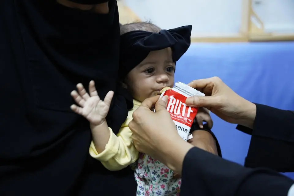 At a UNICEF-supported health center in Aden, Yemen, a malnourished baby eats Ready-to-Use Therapeutic Food.