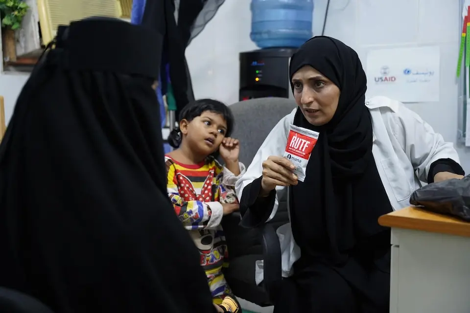 A doctor gives a supply of Ready-to-Use Therapeutic Food to the mother of a malnourished child at a UNICEF-supported health center in Aden, Yemen.