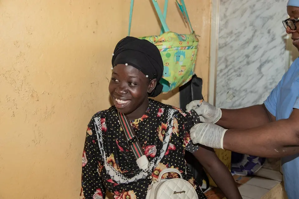 Djenné Kaba, a mother of one, pregnant with her second child, is vaccinated by Sambou Bayo at Bernay-Fotoba health center in the Matoto commune of Conakry, Guinea.