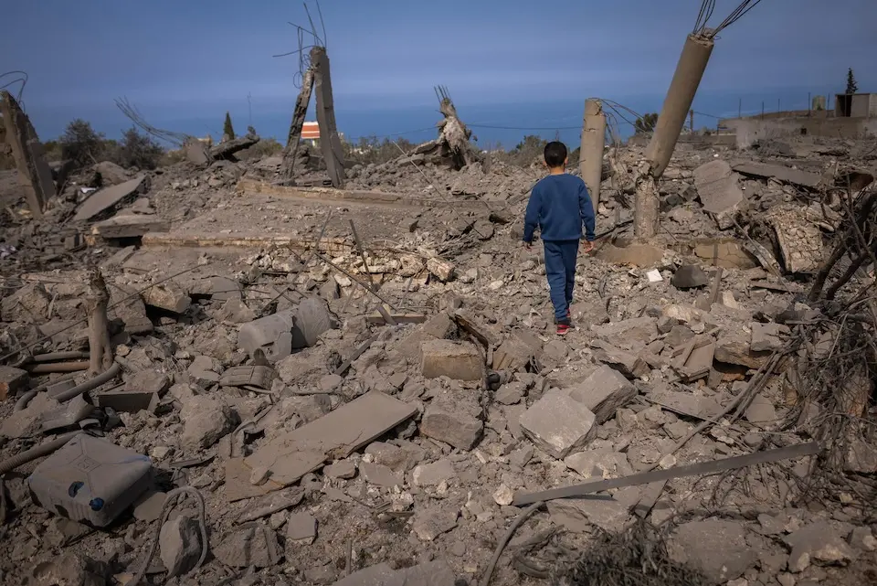 Hassan, 5, walks over rubble in Majdal Zoun, southern Lebanon.
