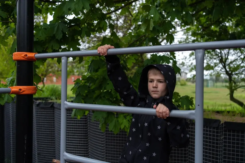 NIne-year-old Andrii climbs up the bars at a playground in Kherson, Ukraine.