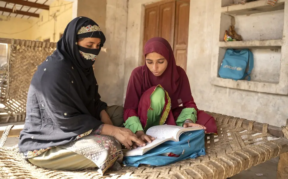 Muqadas, right, helps her mother Salma Qadeer in studies at home in Punjab Province, Pakistan..   