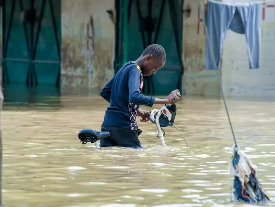 A boy steers his bicycle through floodwaters in Maiduguri, Nigeria.