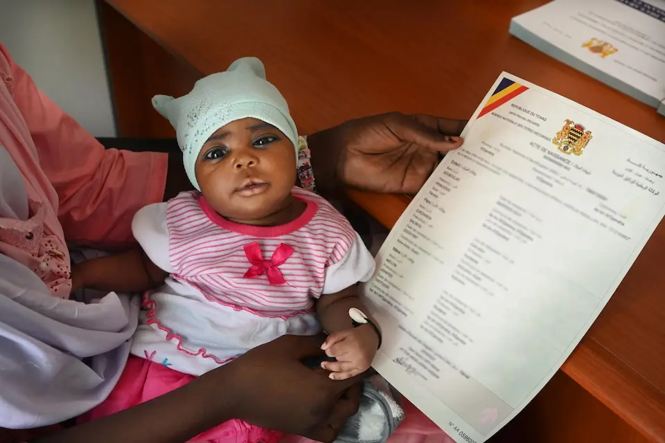 In Chad, a mother cradles her daughter while holding the girl's birth certificate at the healthy facility where the parents had come to have their baby vaccinated. Printing it out was an easy process that took less than 10 minutes thanks to a new digital app UNICEF helped deploy in the country.