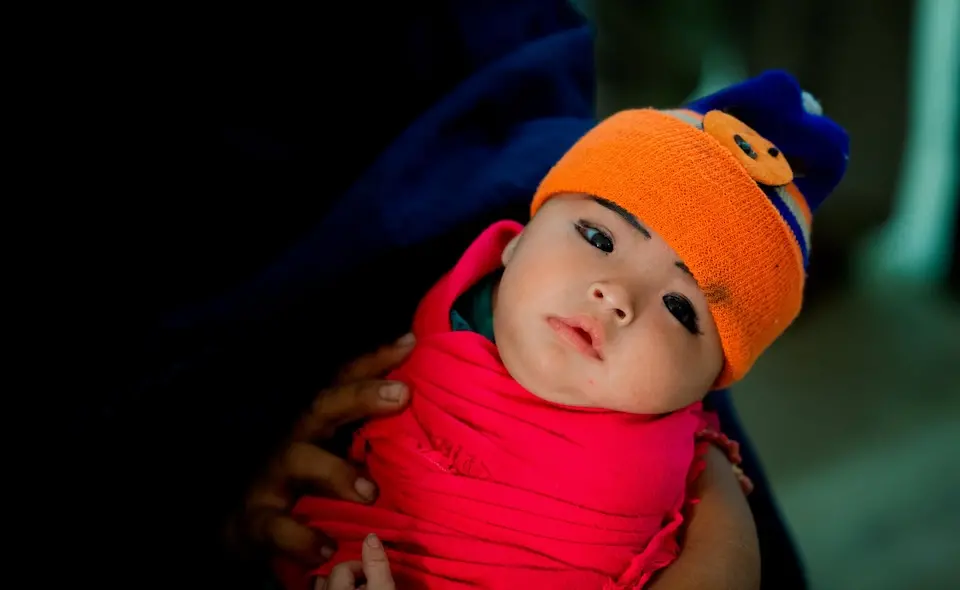 A woman cradles a child in the waiting room of Jannat Gul Hospital in the suburb of Gujro, Pakistan. As the only health facility in the area, the hospital sees a large number of children and families every day, performing many services including birth registration.
