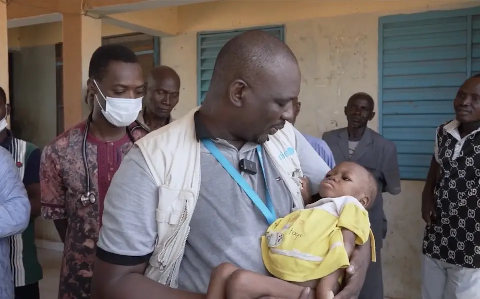 UNICEF Emergency WASH Officer Daouda Sanou cradles 2-year-old Maiga, who is suffering from severe acute malnutrition, at a UNICEF-supported health and nutrition center in Arbinda, northern Burkina Faso, one of the hardest-to-reach places for humanitarian responders.