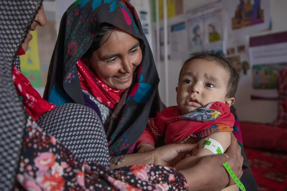  Eidmaa, a 27-year-old CHW at Khakbadak Health Post in Afghanistan is measuring the mid-upper arm circumference of a toddler. Eidmaa has been a CHW for 10 years. 