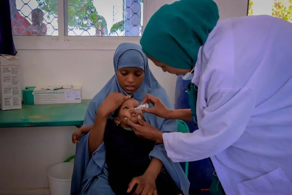 Nurse Basro, a community health worker in Somalia, administers the polio vaccine to a child. 