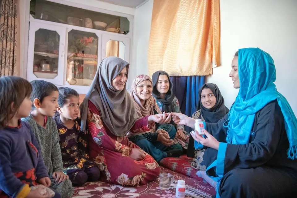A woman receives folic acid from a UNICEF Afghanistan Program Associate at a UNICEF-supported household visit in central Afghanistan.