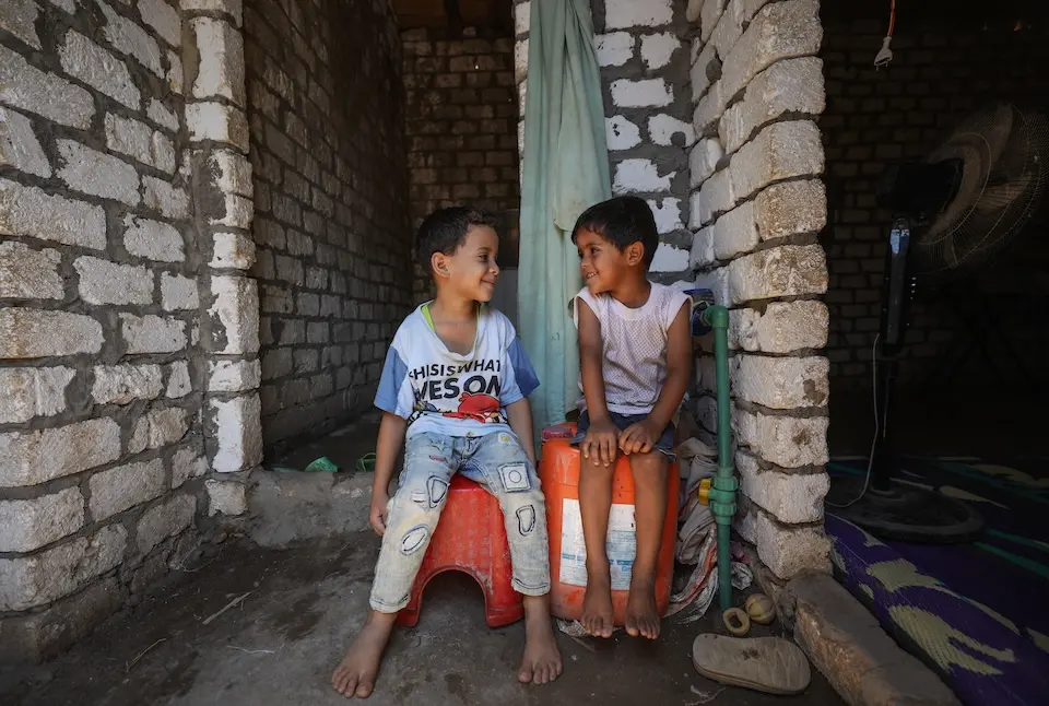 Smiling children in Fayoum, Upper Egypt, outside their home that is now equipped with a new safe water tap thanks to a UNICEF-supported initiative to make safe water more accessible to poor households.