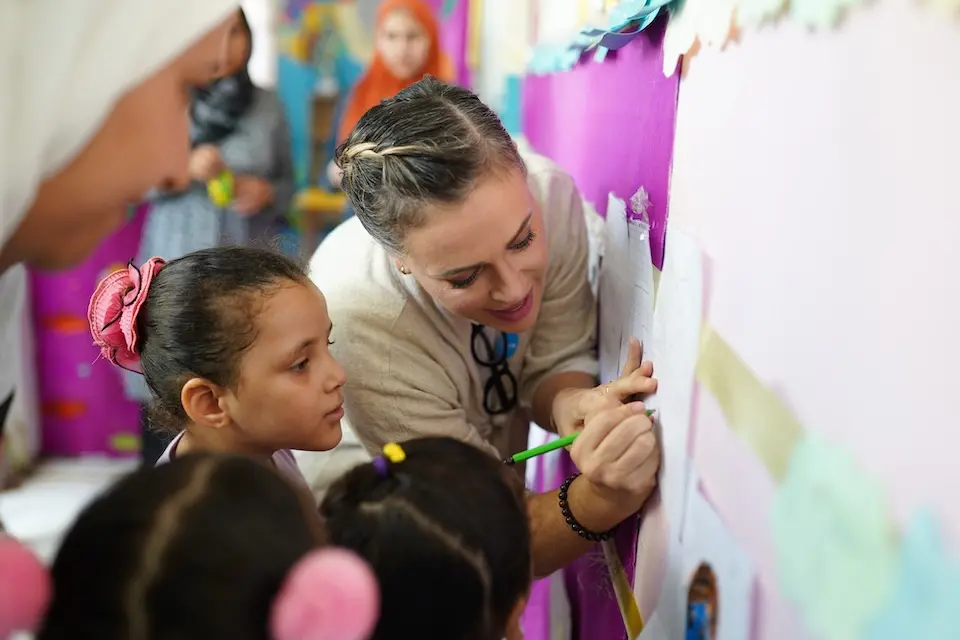 Alyssa Milano interacts with a young girl during a UNICEF program visit.
