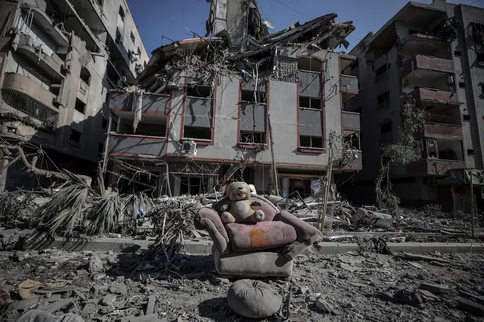 On Oct. 30, 2023, a child's stuffed toy on a couch is surrounded by debris on a street, with damaged buildings in the background, following the escalation of hostilities in the Gaza Strip.