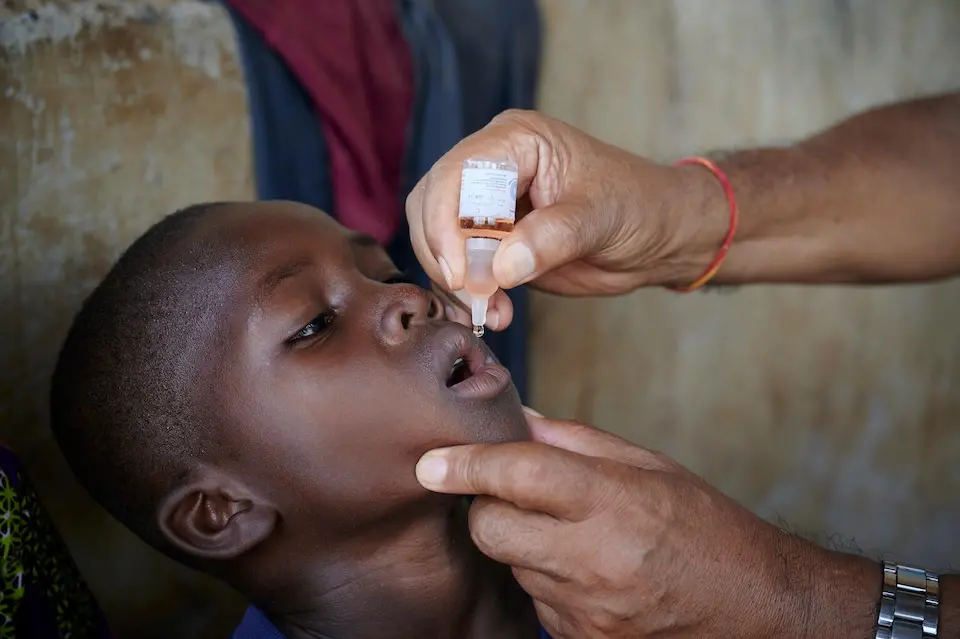 During visit to monitor vaccination coverage in remote communities, Bhanu Pathak, UNICEF Chief of Field Office, administers a polio vaccine to a child in Northern Ghana. UNICEF works with the Ghana Ministry of Health and provides technical and financial support to strengthen immunization coverage and health services in the communities across the country.